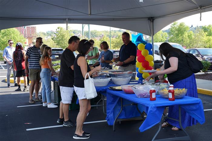 People gather to get food at the AIU Back-to-School Celebration